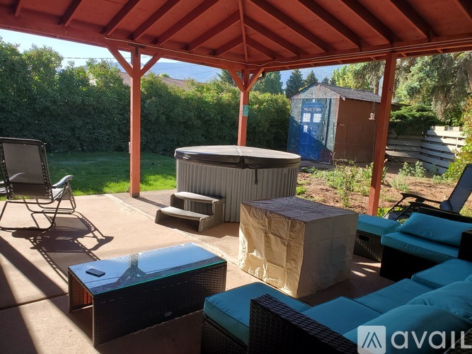 A patio with a table, chairs, and a hot tub.