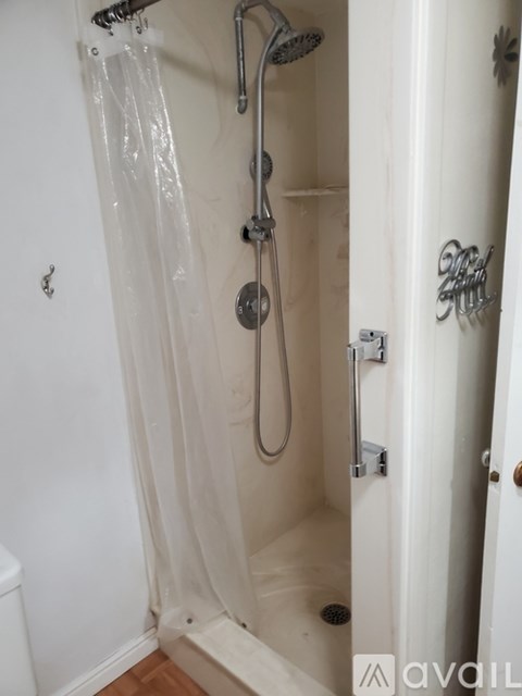 A white bathroom with a shower and a toilet.