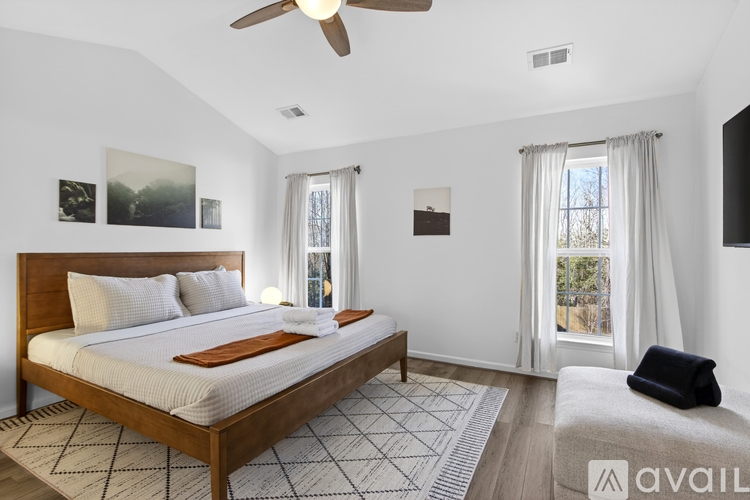 A bedroom with a large bed and a ceiling fan.