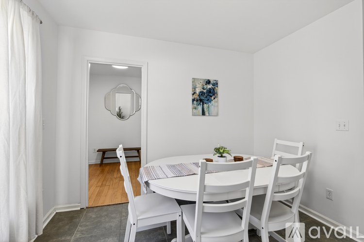 A dining room with a white table and chairs.