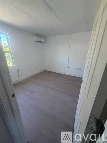 A room with a window and a wall-mounted air conditioner unit.