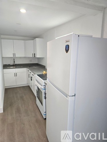 A white refrigerator with a sticker on it in a kitchen.