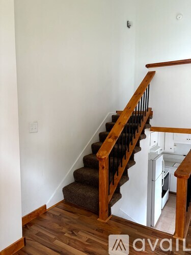 A wooden staircase with a white wall on the side.
