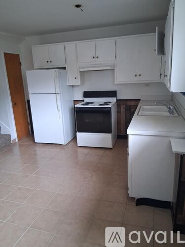 A kitchen with white appliances and cabinets.
