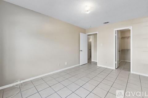 A room with tile flooring and two open doors.