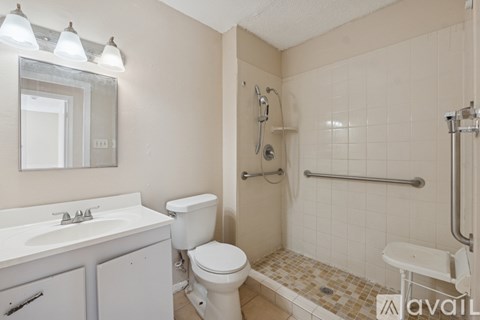 A bathroom with a toilet, sink, and shower.