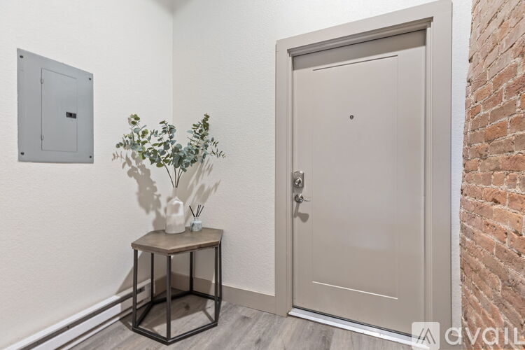 A white door is closed and there is a plant on a table.