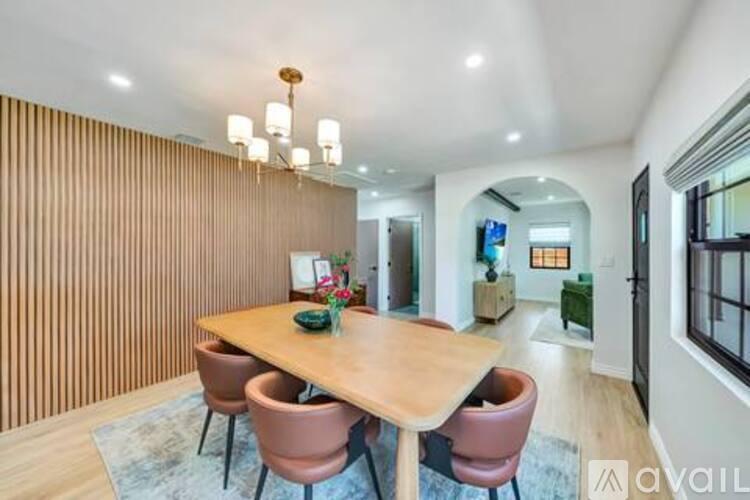 A dining room with a wooden table and chairs.