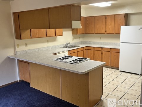 A kitchen with wooden cabinets and a white refrigerator.
