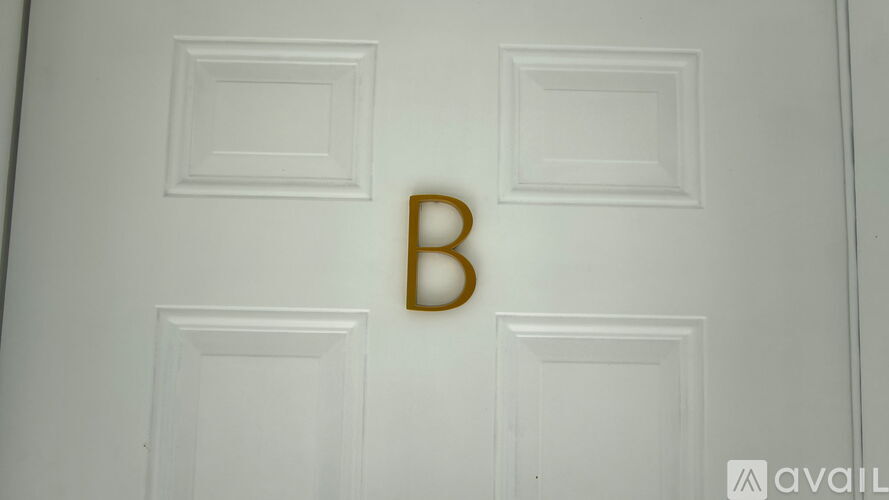 A white door with a gold letter B on it.