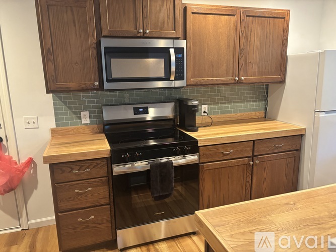 A kitchen with wooden cabinets and a stove top oven.
