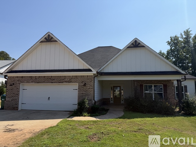 A house with a white garage door and a brick wall.