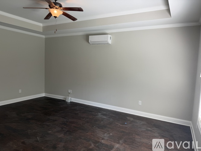 A room with a ceiling fan and a wall-mounted air conditioner unit.