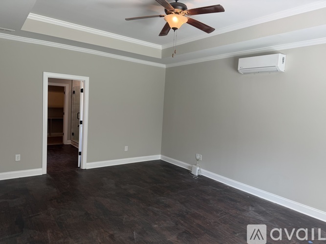A room with a ceiling fan and a wall-mounted air conditioner unit.