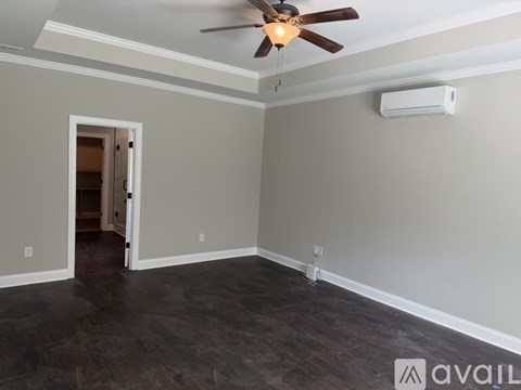 A room with a ceiling fan and a wall-mounted air conditioner unit.