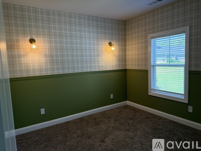 A room with green walls and a window with blinds.
