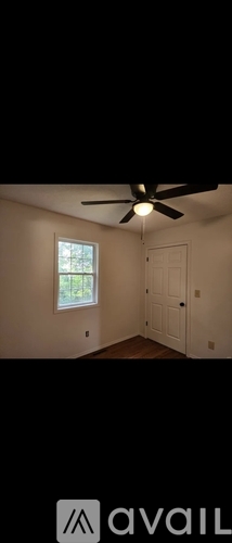 A room with a ceiling fan and a window.