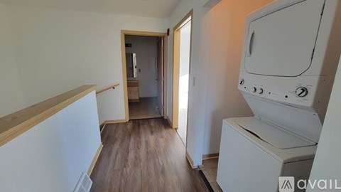 A white oven is in a kitchen with wooden floors and white walls.