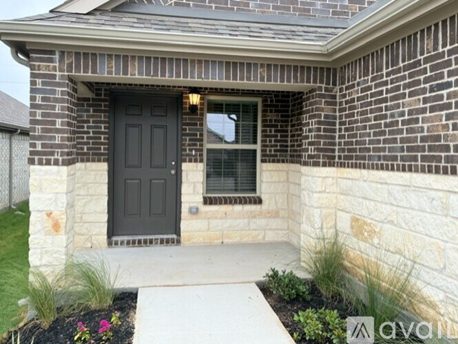A house with a black door and a window is shown.