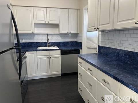 A kitchen with white cabinets and a blue countertop.
