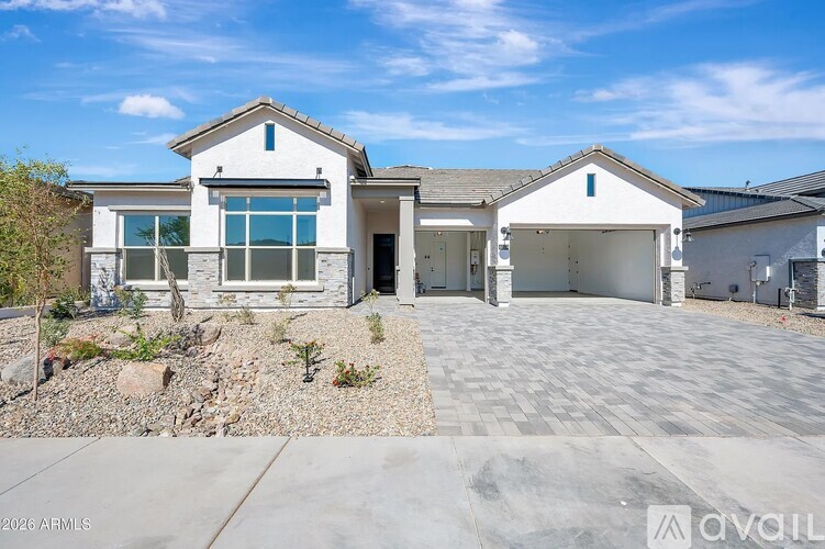 A modern house with a white exterior and a large driveway.
