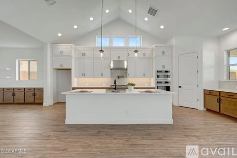 A modern kitchen with white cabinets and a central island.