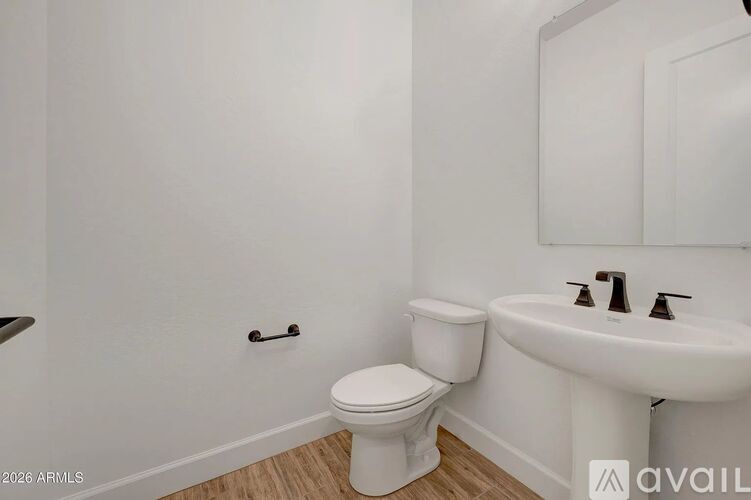 A white toilet and sink in a small bathroom.