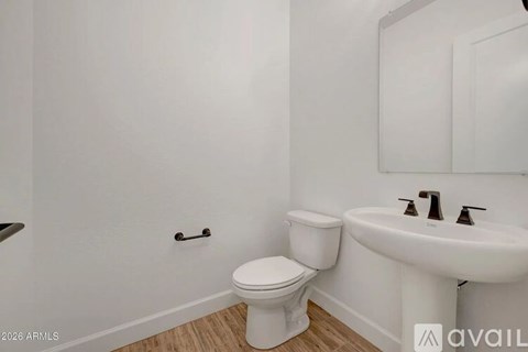 A white toilet and sink in a small bathroom.