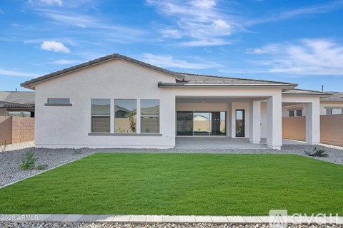 A modern house with a white exterior and a large front yard.