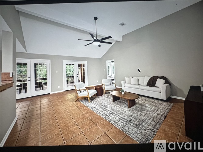 A living room with a white couch, a coffee table, and a ceiling fan.