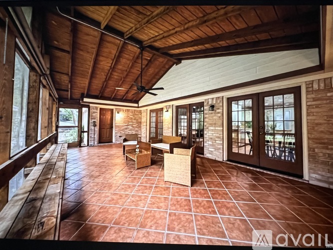 A spacious room with a wooden ceiling and tiled floor.