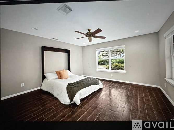A bedroom with a large bed and a ceiling fan.