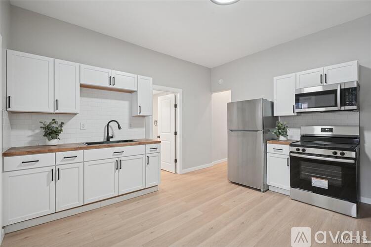 A kitchen with white cabinets and stainless steel appliances.