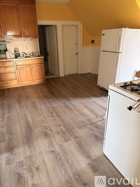 A kitchen with a white fridge and wooden cabinets.