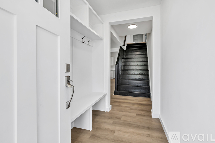 A staircase with a white wall and wooden steps.