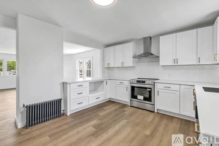 A modern kitchen with white cabinets and stainless steel appliances.