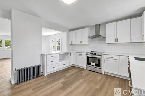 A modern kitchen with white cabinets and stainless steel appliances.