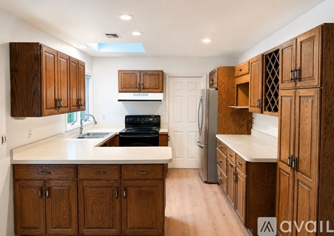 A kitchen with wooden cabinets and appliances.