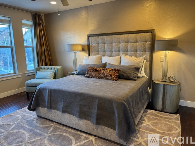 A bedroom with a large bed and a chair.