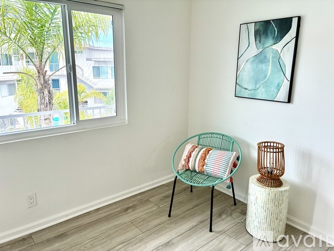 A room with a chair and a painting on the wall.