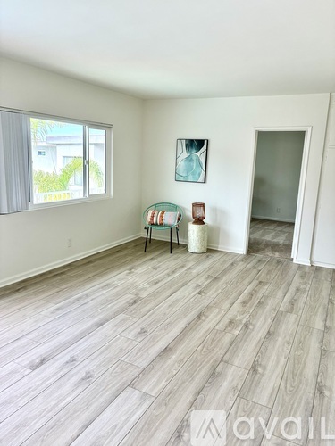 A room with wooden flooring and a painting on the wall.