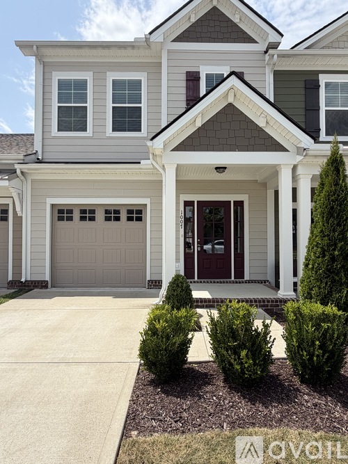 A two-story house with a garage and a brown door.
