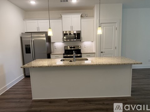 A kitchen with a granite countertop and stainless steel appliances.