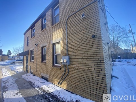 A brick building with a snow-covered ground in front.