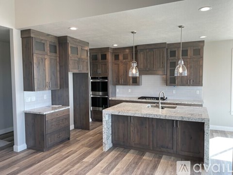 A kitchen with dark wood cabinets and a marble countertop.