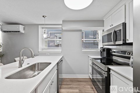 A kitchen with white cabinets and a black stove top oven.