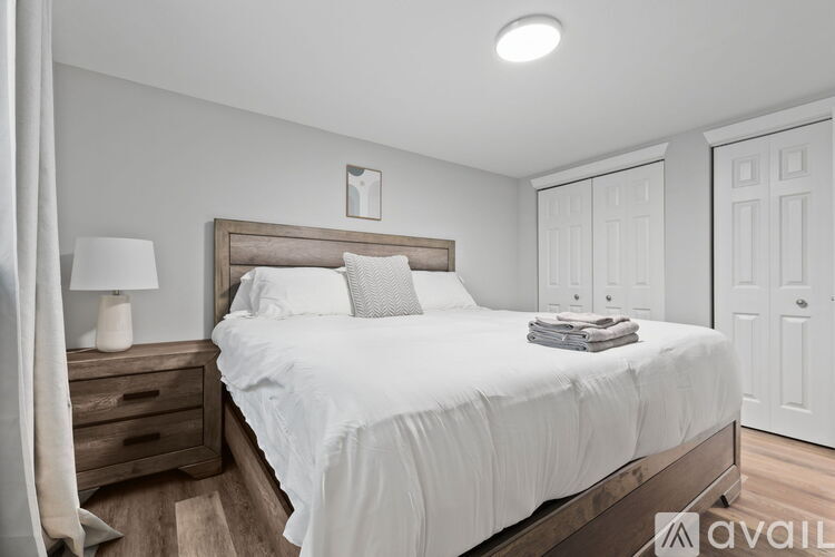 A bedroom with a large bed and a wooden headboard.