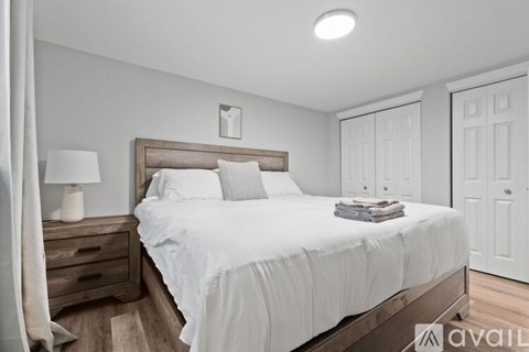 A bedroom with a large bed and a wooden headboard.