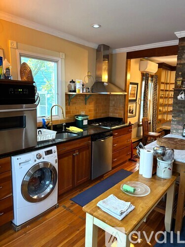 A modern kitchen with a washing machine and a dining table.