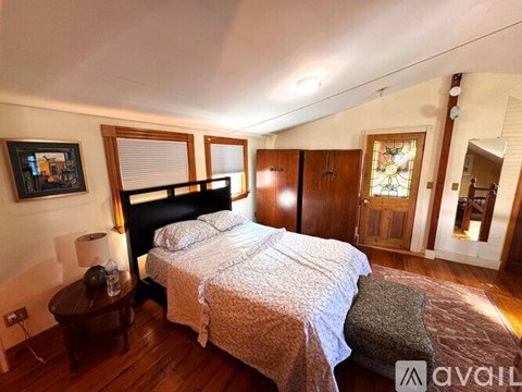 A bedroom with a large bed and a stained glass window.